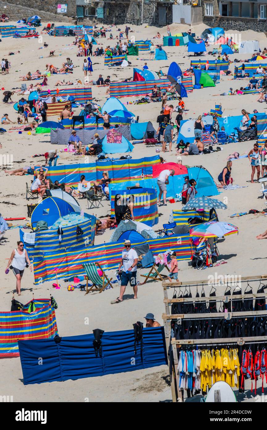 St Ives, UK. 27th May, 2023. People flock to the beach to sunbathe as well as take part in watersports and boat trips - Sunny weather for the bank holiday weekend in St Ives. Credit: Guy Bell/Alamy Live News Stock Photo