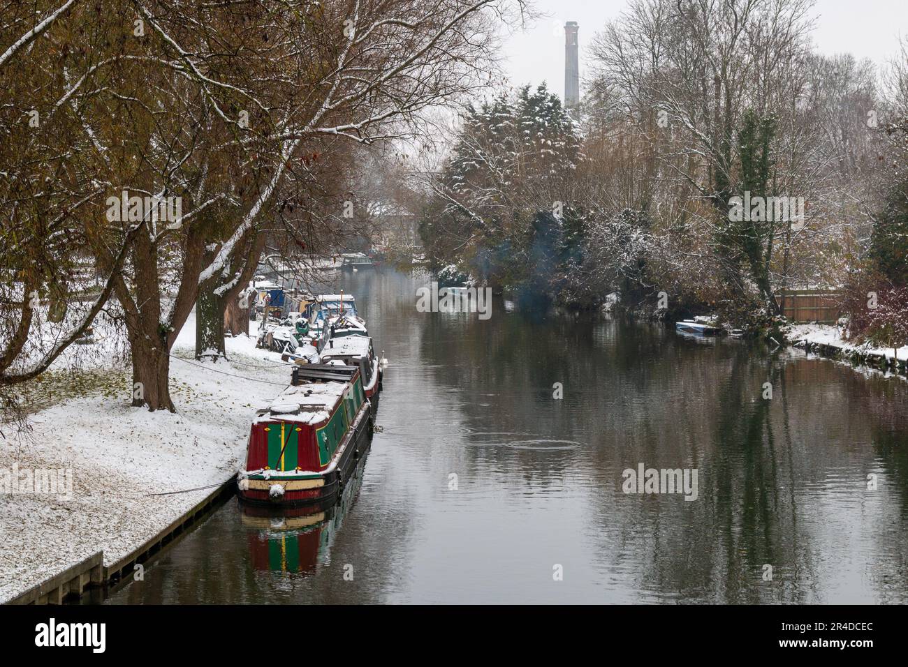 A narrowboat moored on the River Cam at Stourbridge Common, Cambridge, UK on a snowy, winter day. Stock Photo