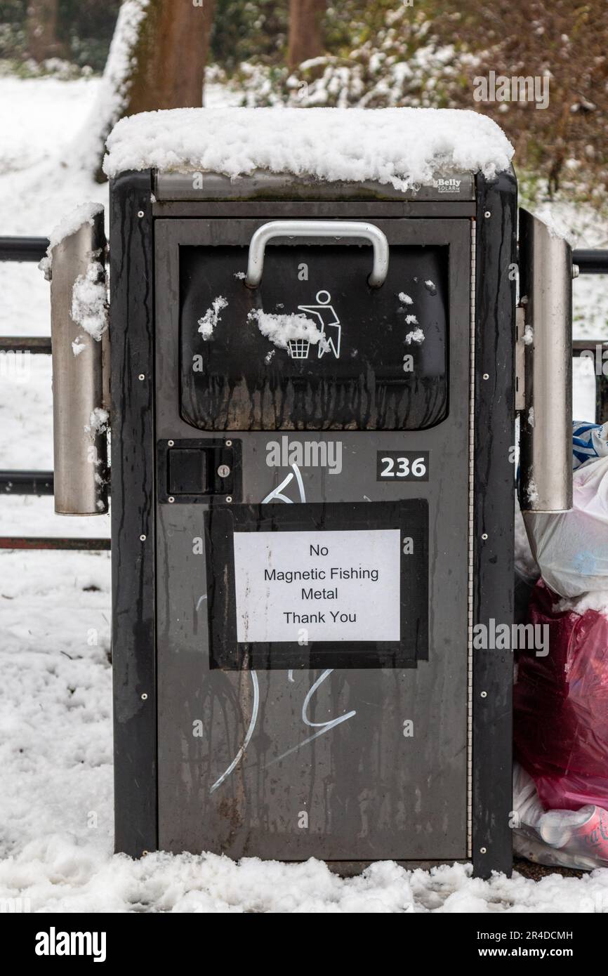 A sign on a bin on Stourbridge Common, Cambridge, UK, on a winter day prohibits magnetic fishing. Stock Photo