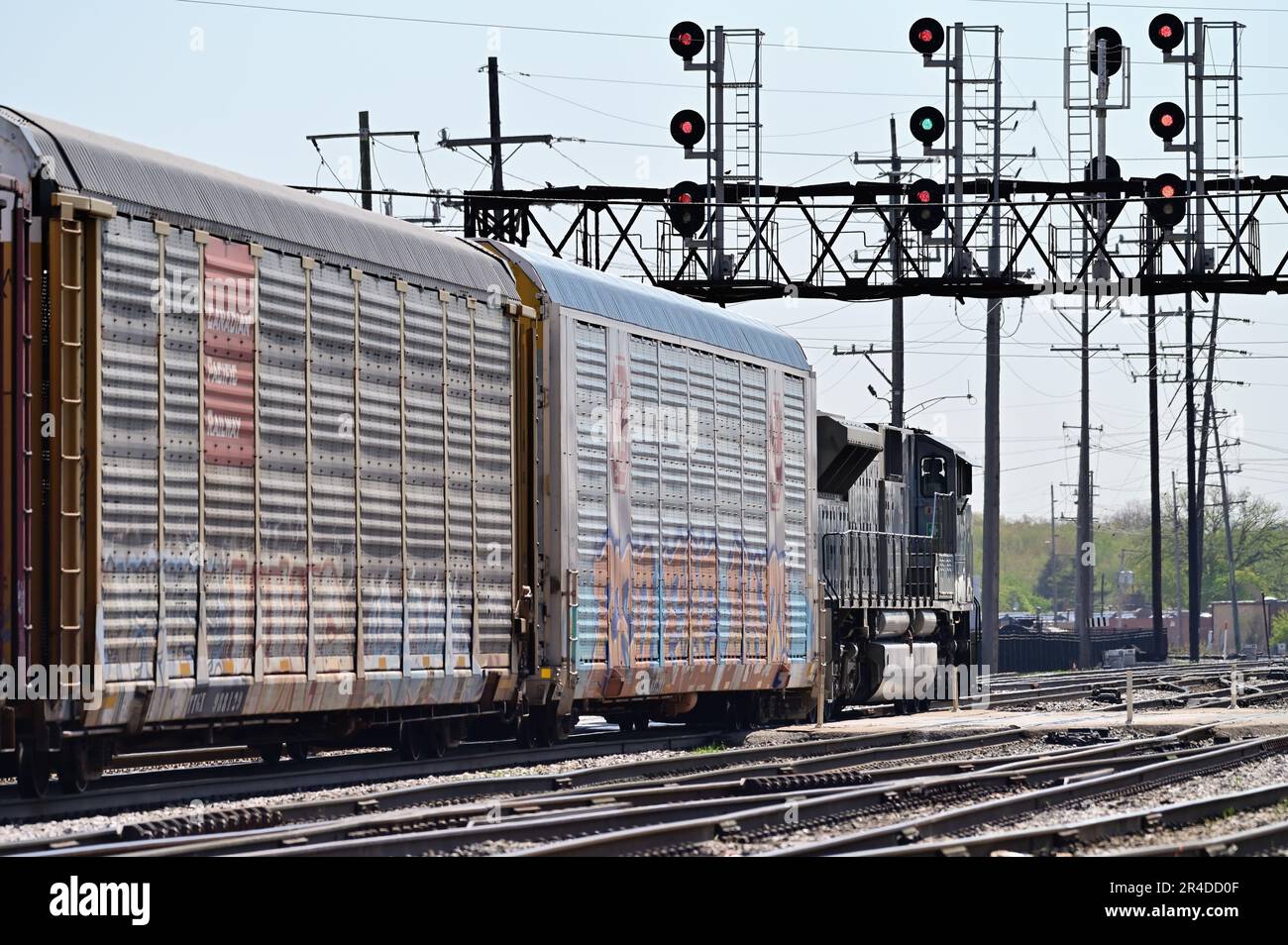 Franklin Park, Illinois, USA. A single locomotive leads a Canadian Pacific Kansas City (CPKC) freight train toward a signal bridge and a green signal. Stock Photo