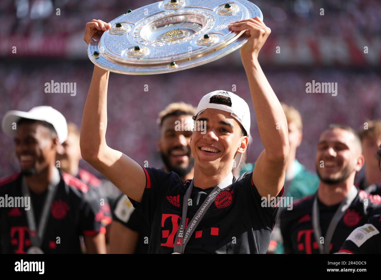 Bayern's Jamal Musiala Lifts The Championship Trophy After The German ...