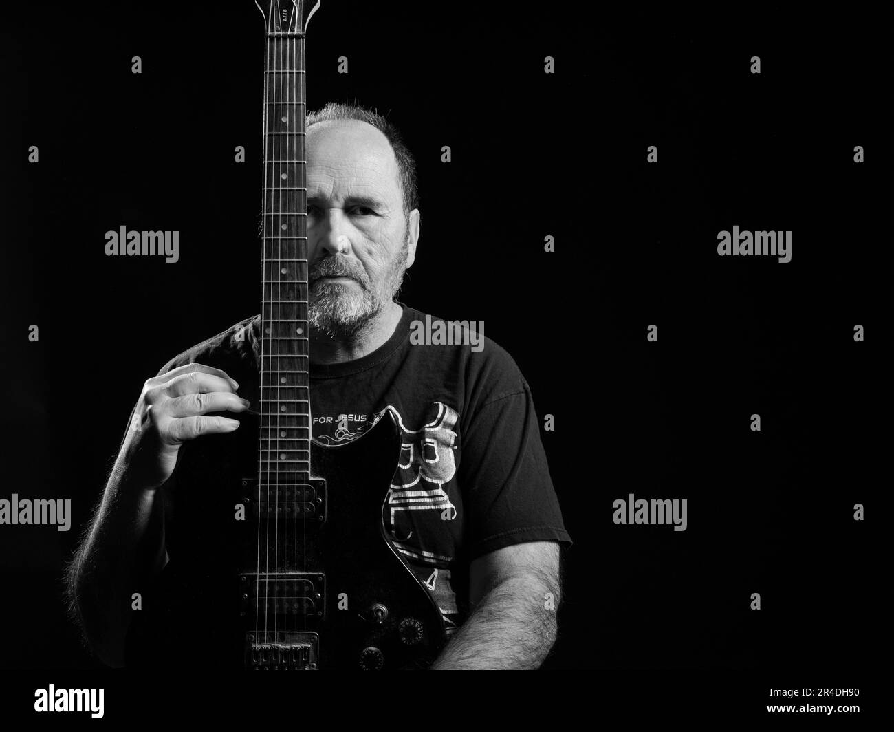 A young man is seen in a dynamic pose, strumming a classic guitar