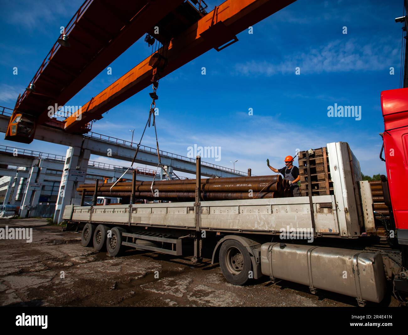 Podolsk, Moscow province - August 02, 2021: Pipes warehouse. Worker load tubes on truck with overhead crane. Stock Photo