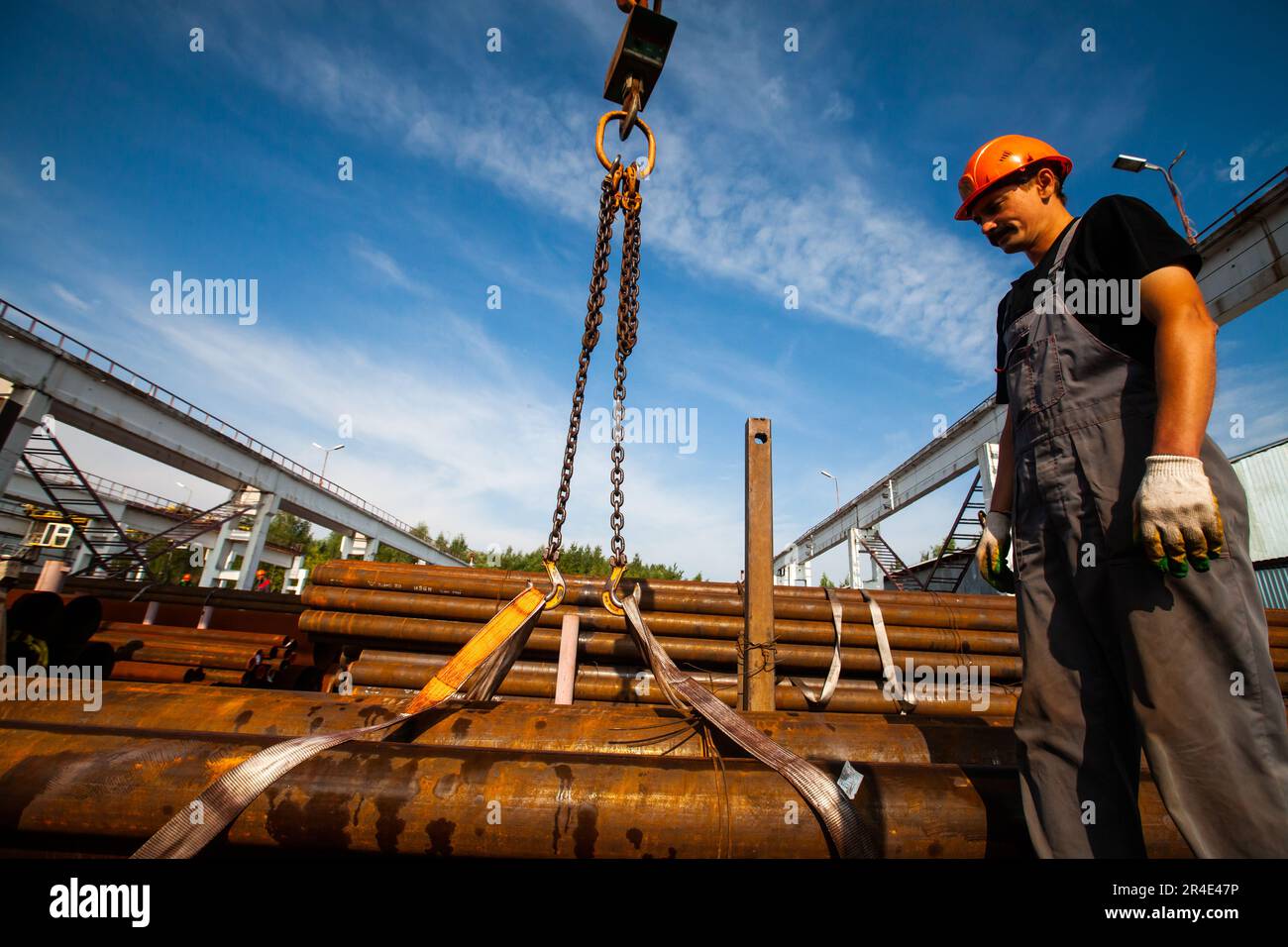 Podolsk, Moscow province - August 02, 2021: Pipes warehouse. Worker load pipes with overhead crane. Stock Photo