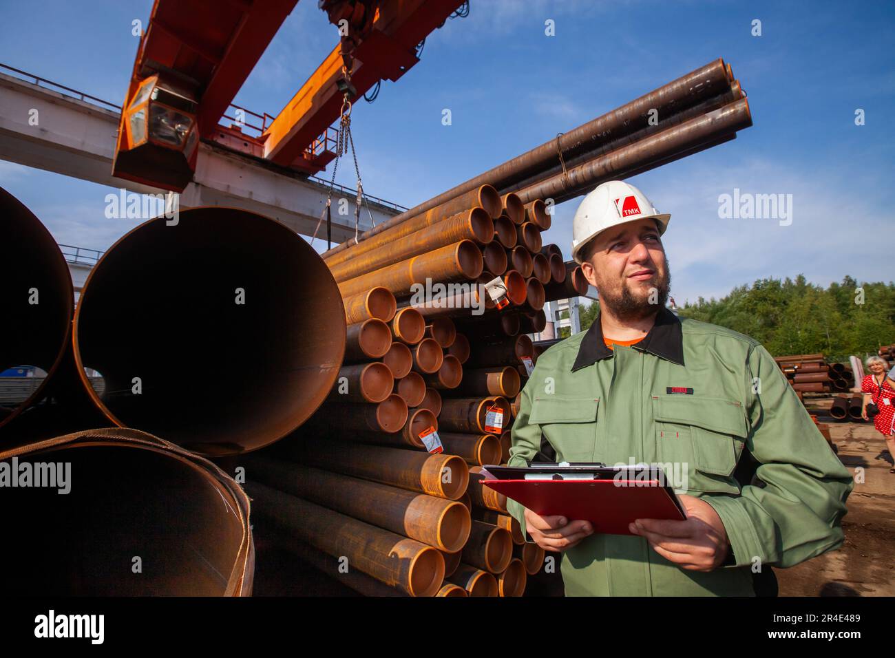 Podolsk, Moscow province - August 02, 2021: Engineer portrait on tubes and  overhead crane background. Pipes warehouse. Stock Photo