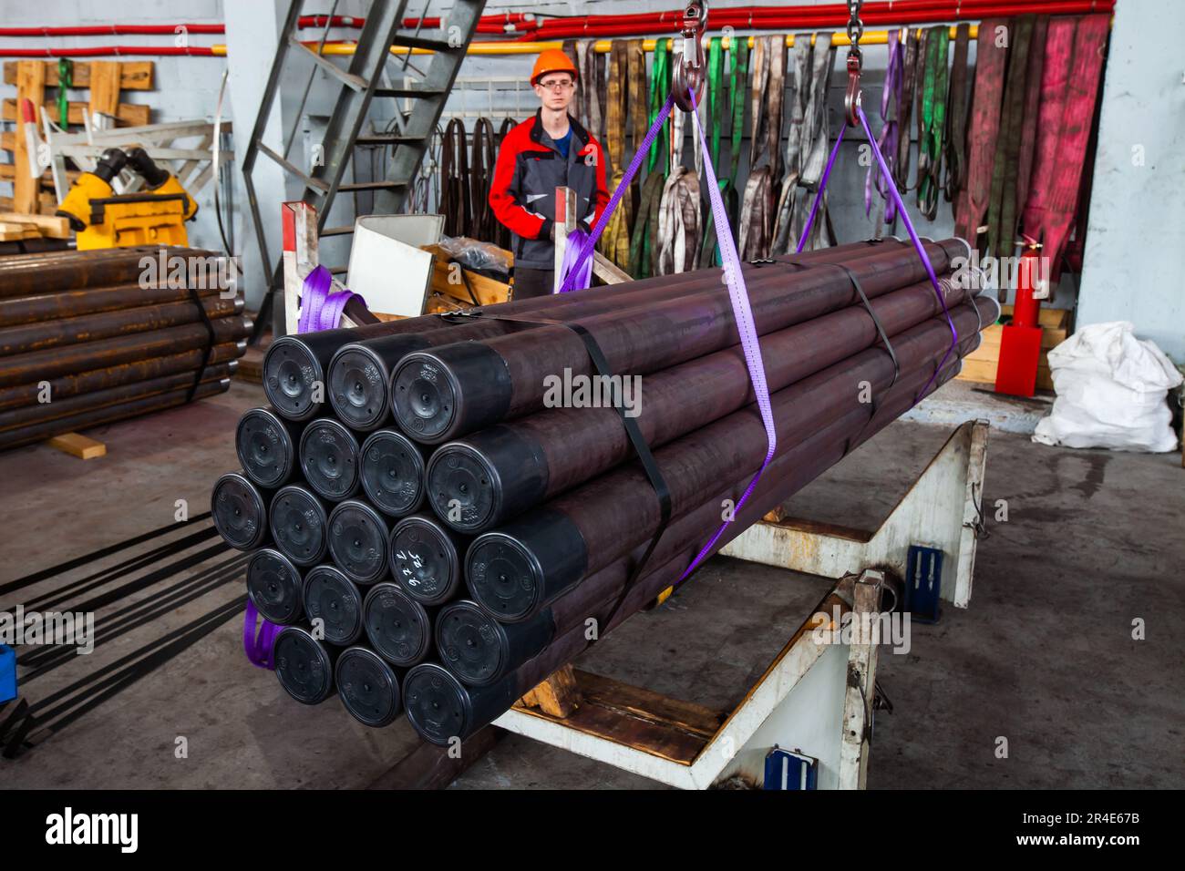 Podolsk, Moscow province - August 02, 2021: Production of oil drill pipes. Worker lifting ready pipes Stock Photo