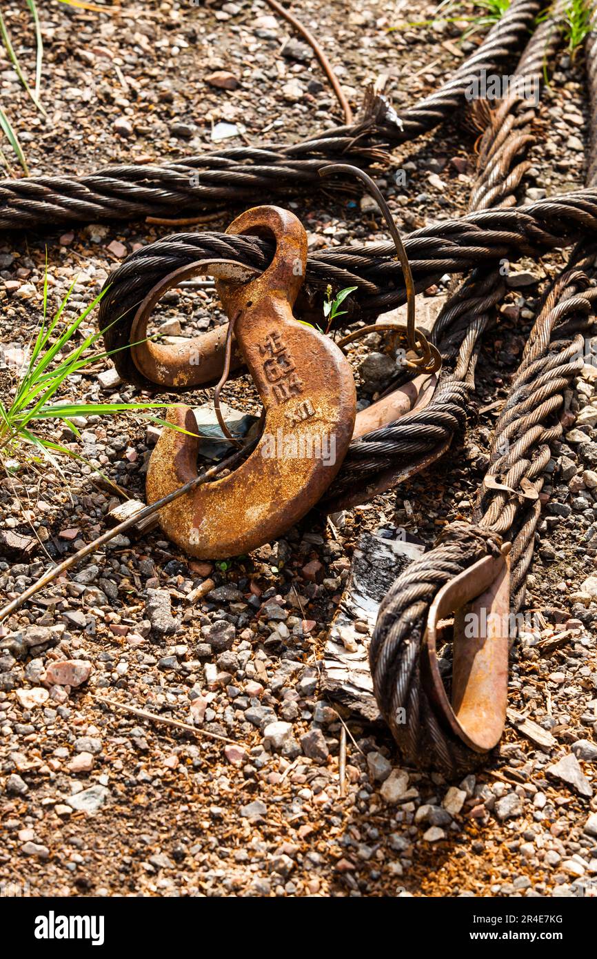 Close-up of rusted steel rope and crane hook on gravel background Stock Photo