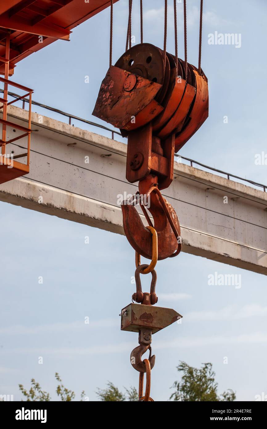 Close-up of rusted crane hook on steel rope against blue sky Stock Photo