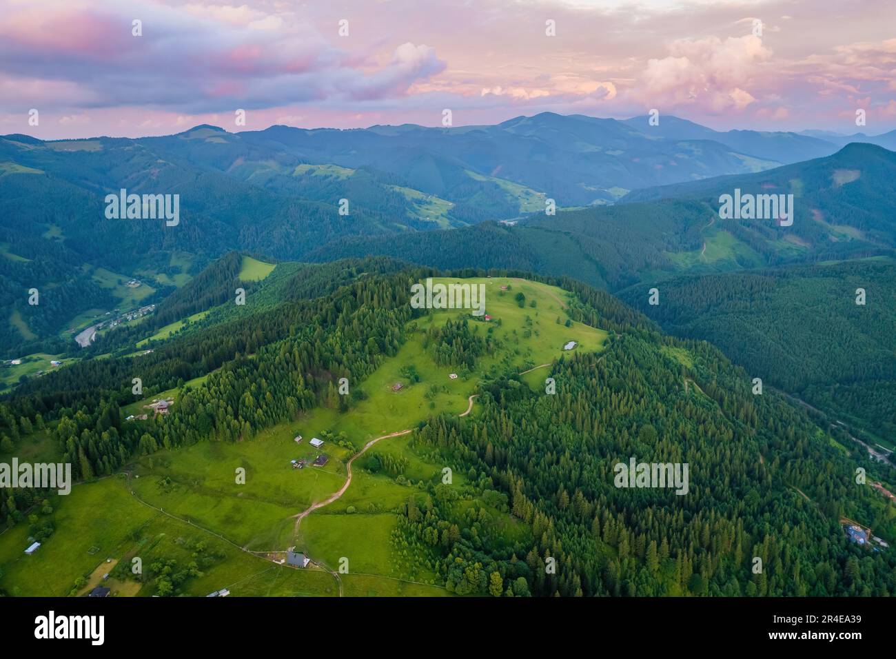 Scenic aerial view of the foggy Carpathian mountains, village and blue ...