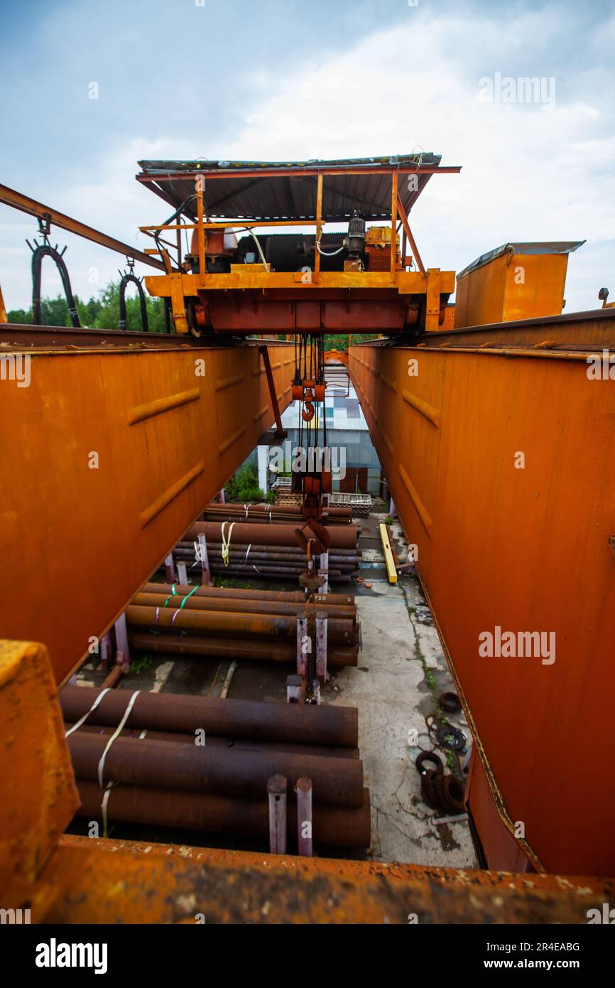 Overhead crane boom from top to bottom closeup photo. Rusty pipes down ...