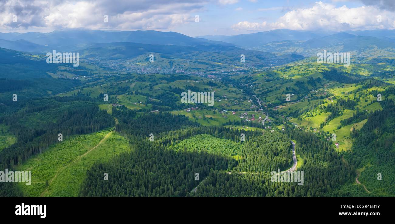 Scenic aerial view of the foggy Carpathian mountains, village and blue ...