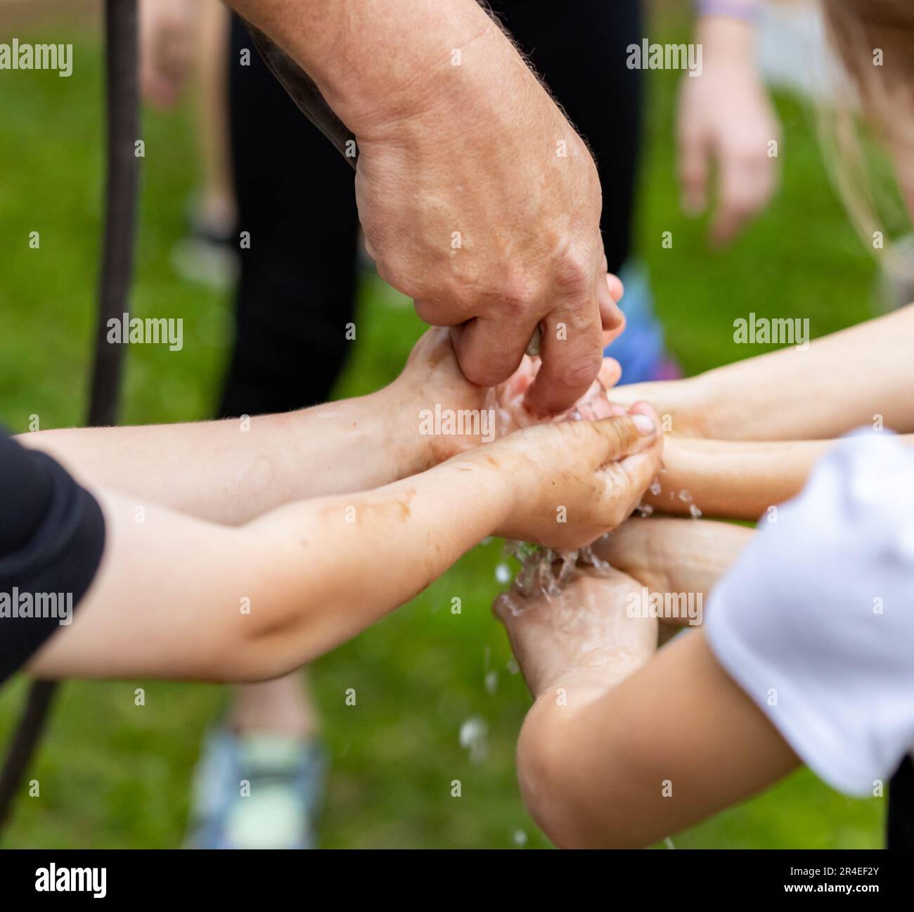 Kids washing hands with water house outdoors Stock Photo