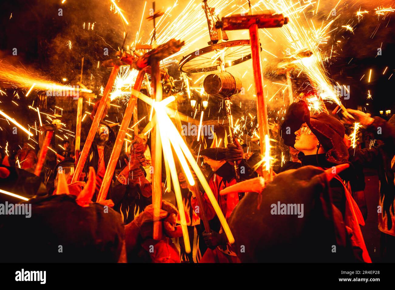 Barcelona, Spain. 27th May, 2023. Fire runners in devil costumes gather to enlighten their stick mounted firecrackers during a 'Correfocs' in Barcelona's Gracia neighborhood. Credit: Matthias Oesterle/Alamy Live News Stock Photo