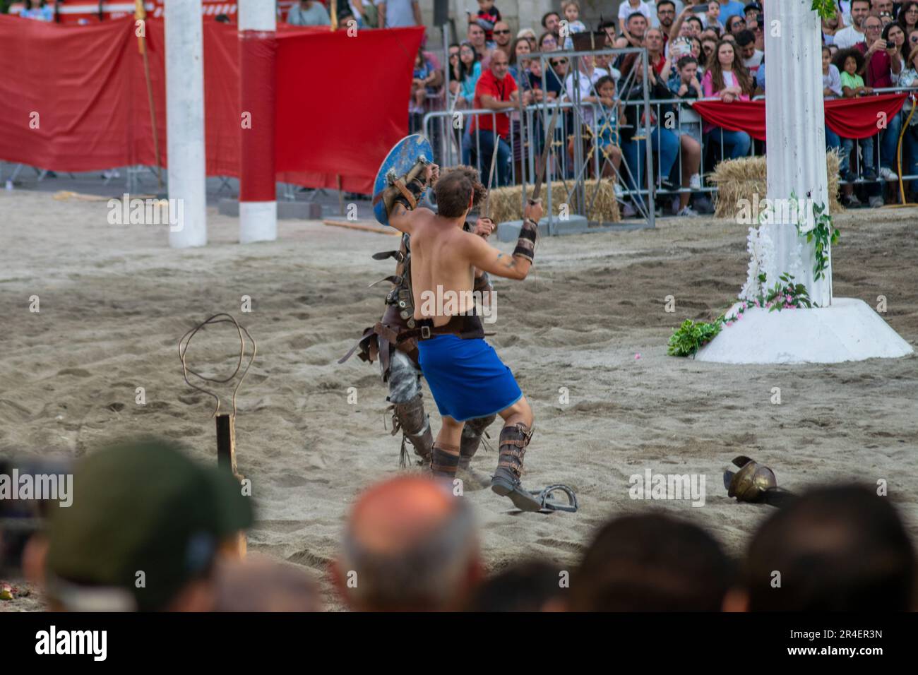 Roman games, gladiators fighting for life, theatrical fight of Roman gladiators. War games. Gladiators performing for crowded spectators. Stock Photo