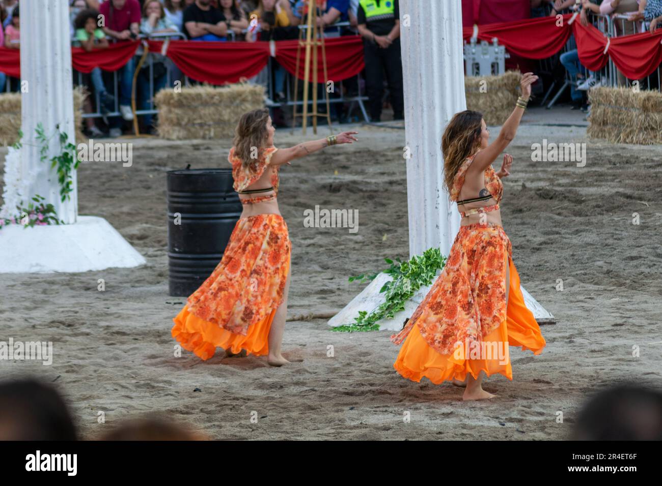 Two women's dancing for Roman crowd at Braga Romana event. Historical representation of Roman spectacles for crowd entertainment purposes. Sensual dance Stock Photo