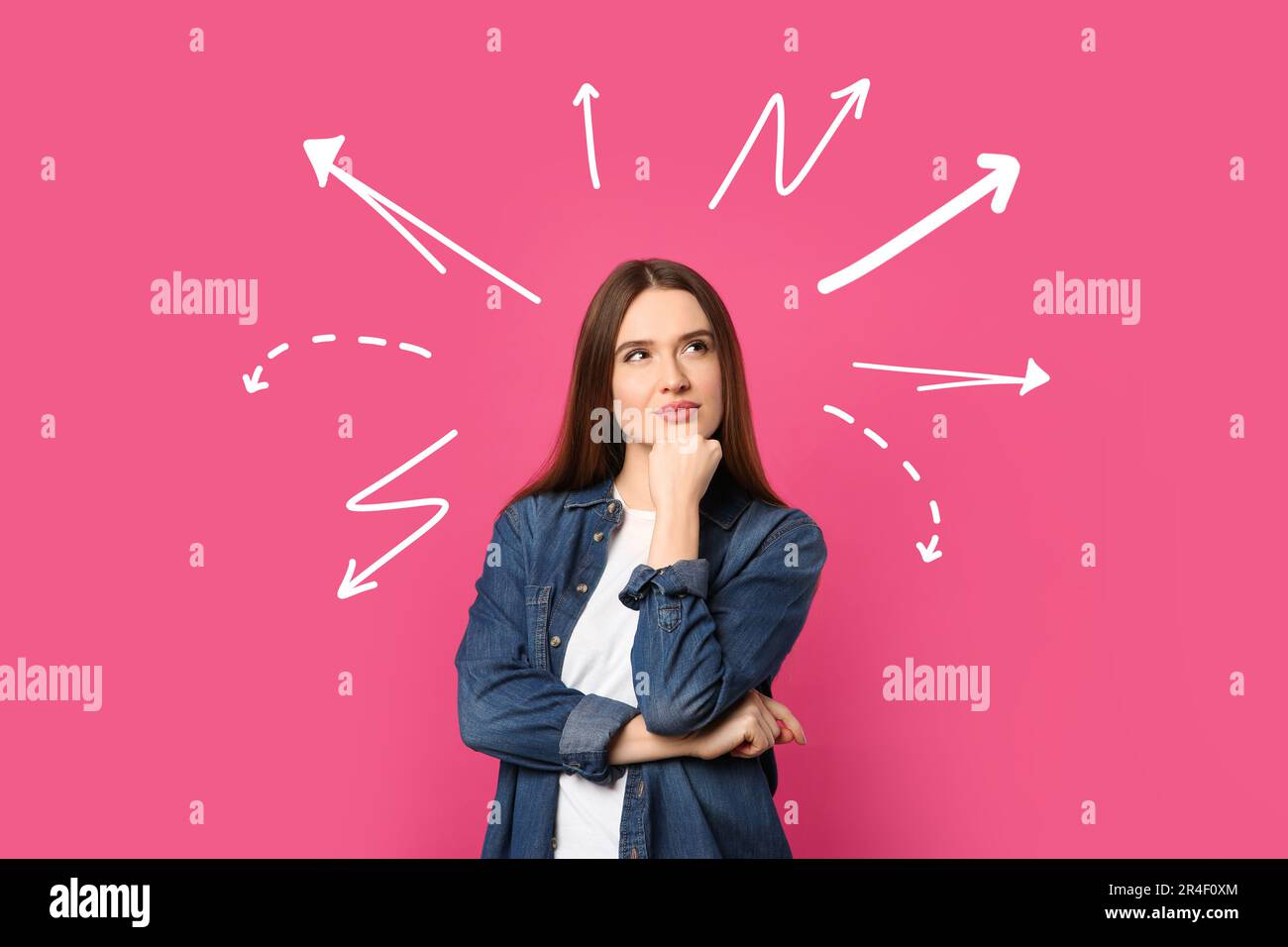Choice in profession or other areas of life, concept. Making decision, thoughtful young woman surrounded by drawn arrows on pink background Stock Photo