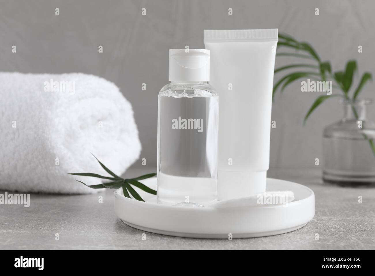 Micellar water and cream on grey table Stock Photo