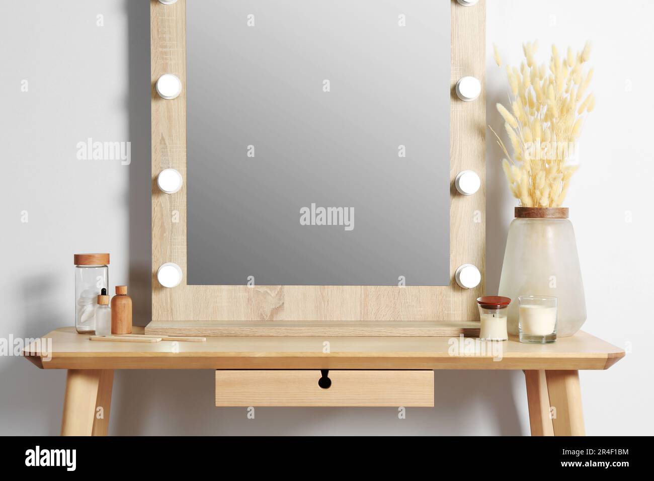 Dressing table with stylish mirror, dried reeds and other decorative ...