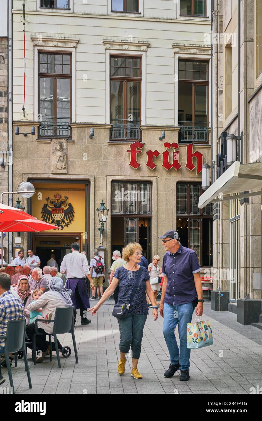 Senior couple enjoying a day of shopping as they pass by the famous Cologne beer hall called the