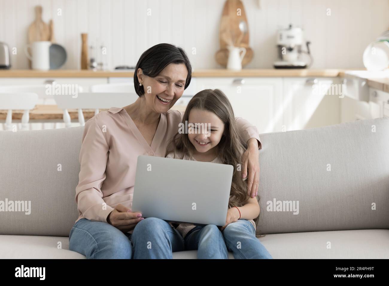 Happy mature grandma and cute grand child girl using laptop Stock Photo ...