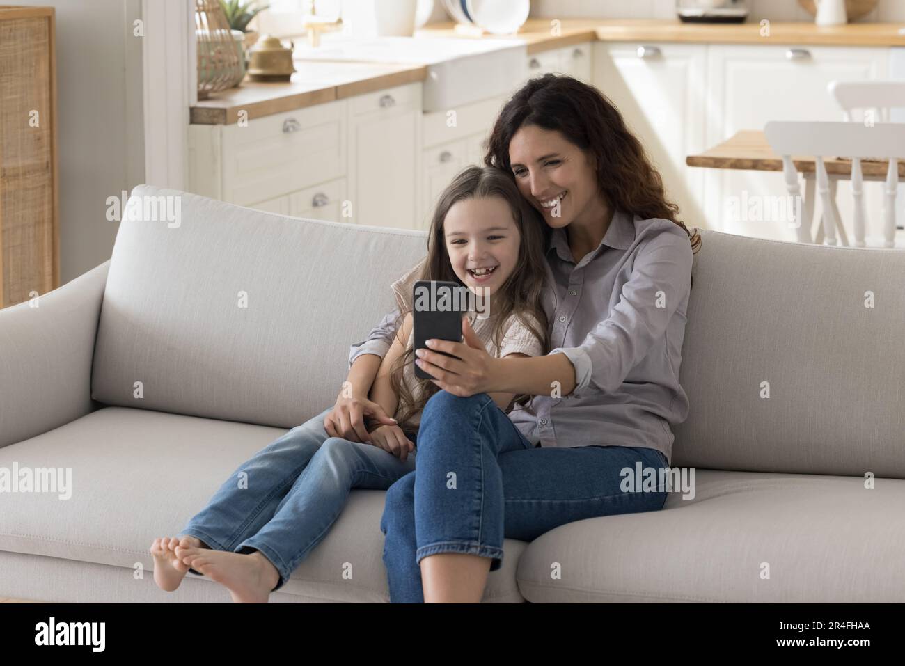 Happy Latin mom and child girl using app on smartphone Stock Photo - Alamy