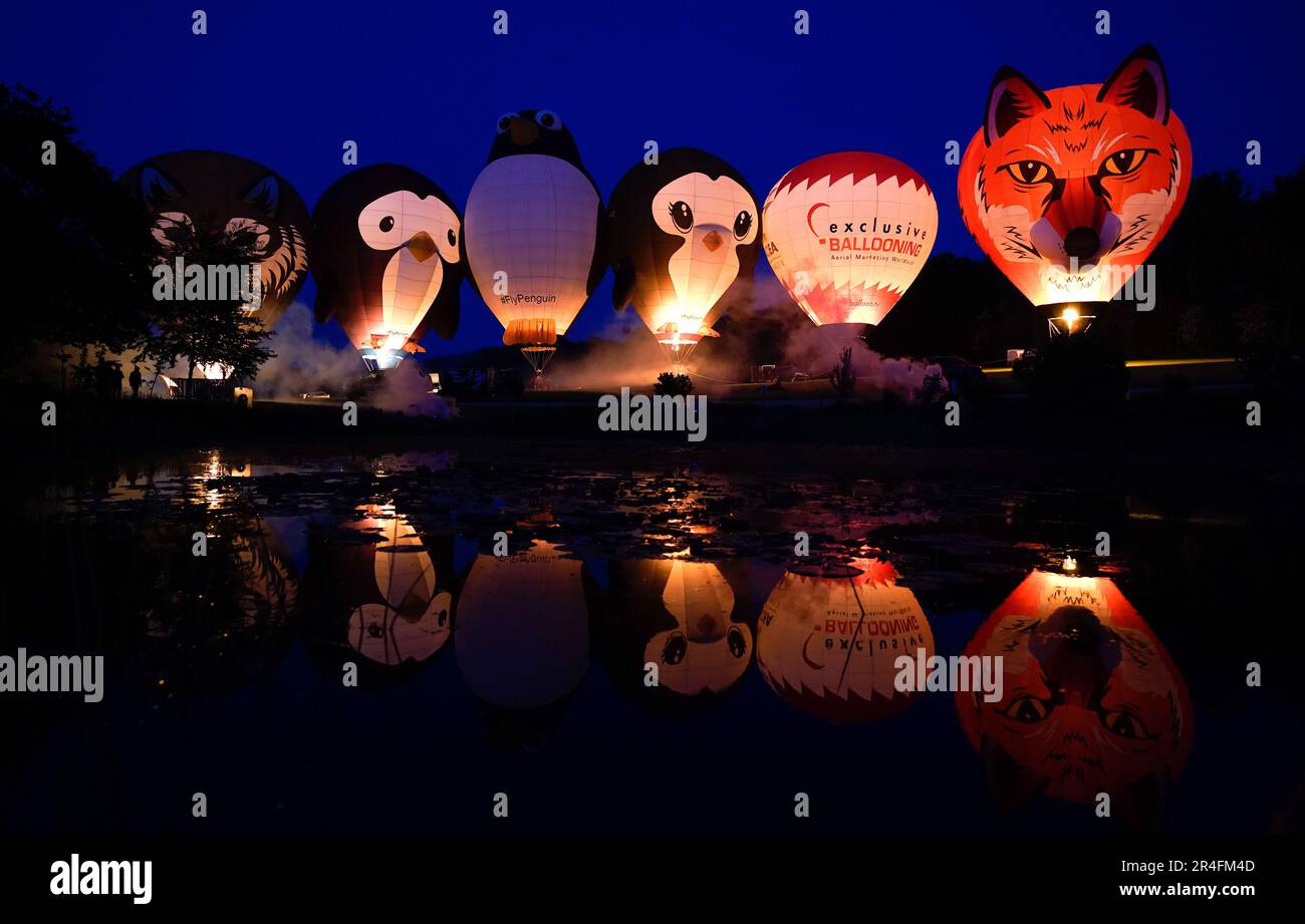 Balloons light up as they are tethered to the ground as they take part