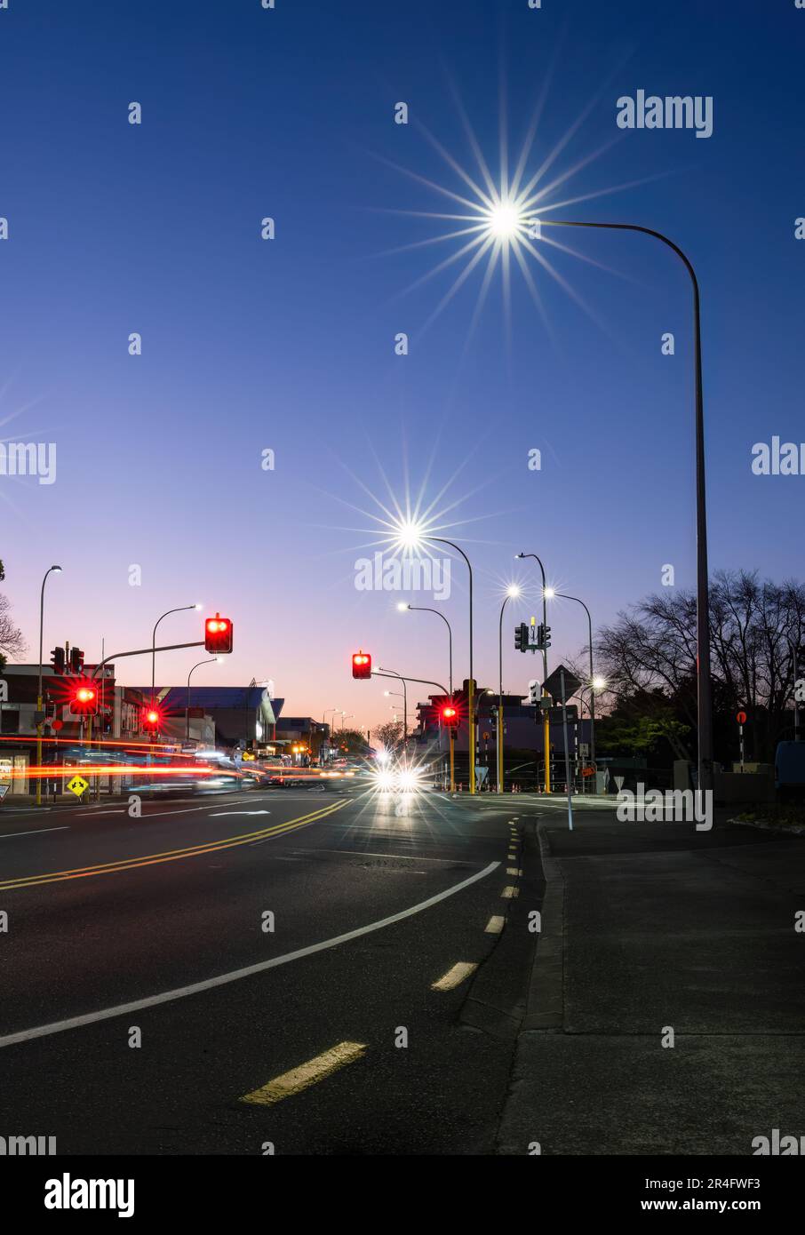 Car light trails at red traffic light on road intersection. Auckland. Vertical format. Stock Photo