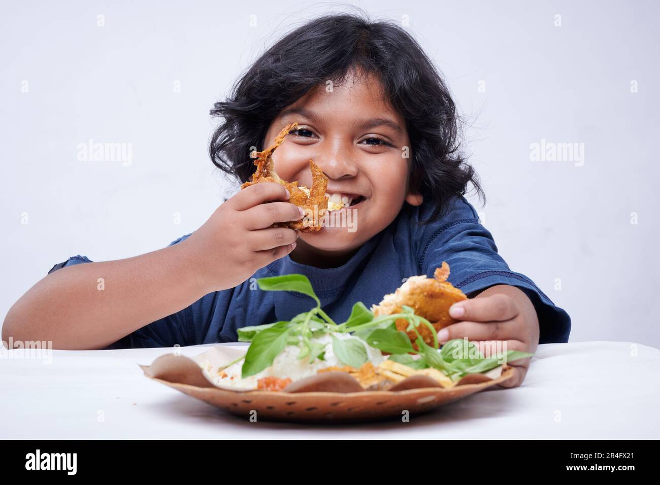 Little Girl Eating Fried Chicken, rice with vegetable and spicy souce