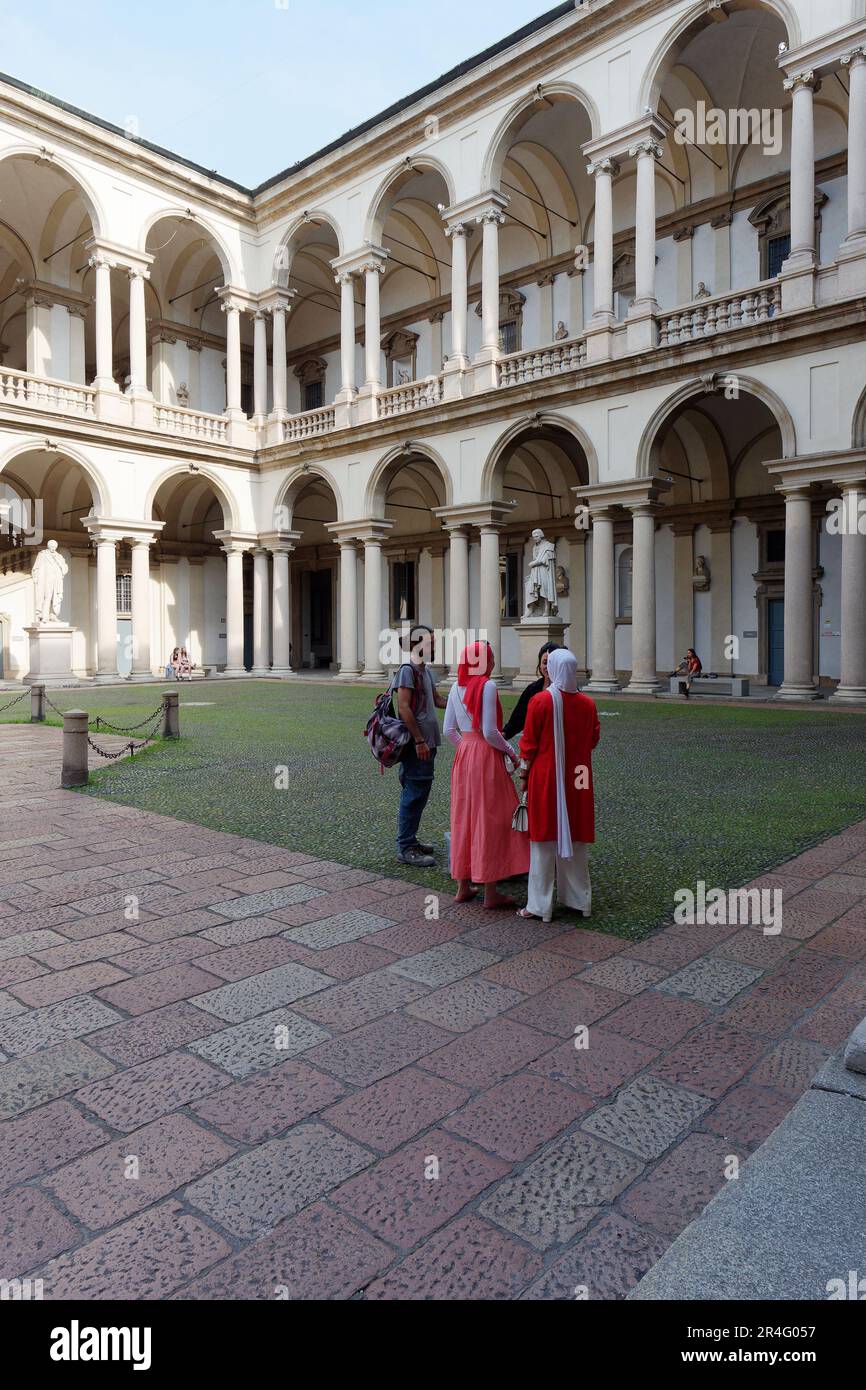 Tourists in Palazzo di Brera (Brera Palace) courtyard, city of Milan, Lombardy, Italy. The Palace houses the famous Pinacoteca (Art Gallery) Stock Photo