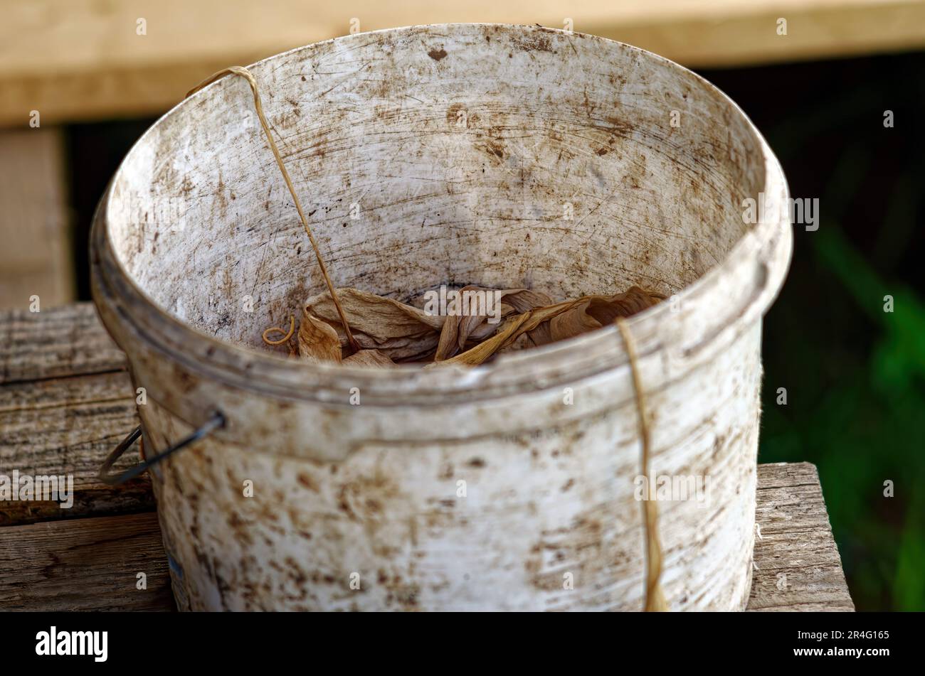 An old plastic bucket with garbage, in the village Stock Photo