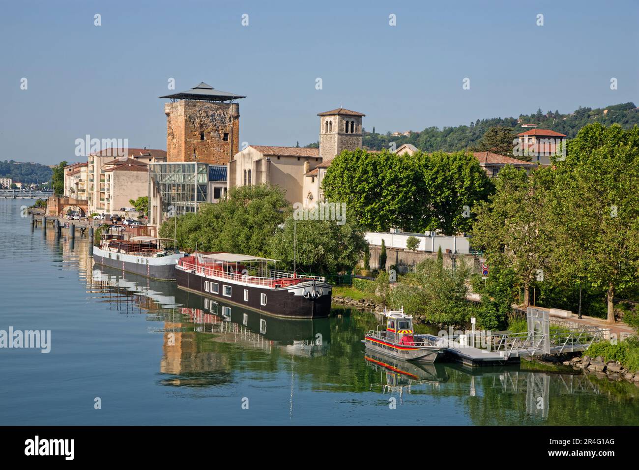 VIENNE, FRANCE, May 26, 2023 : Valois tower, built in 1336 by French King Philippe VI and Cordeliers church on the right bank of Rhone river. Stock Photo