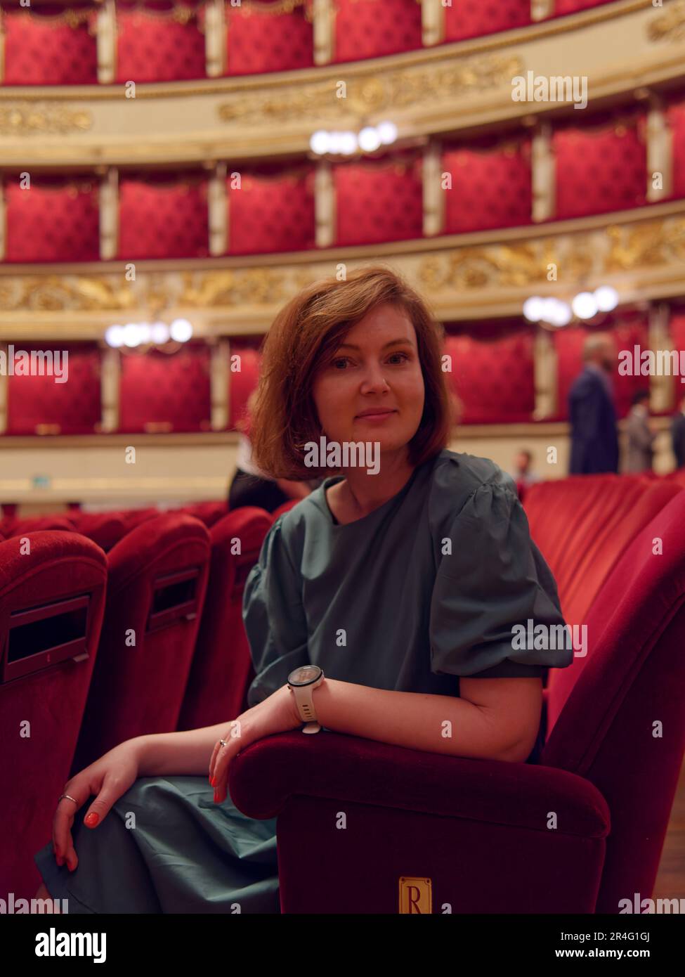 Pretyy lady in green outfit inside La Scala Opera House in Milan, Lombardy, Italy Stock Photo