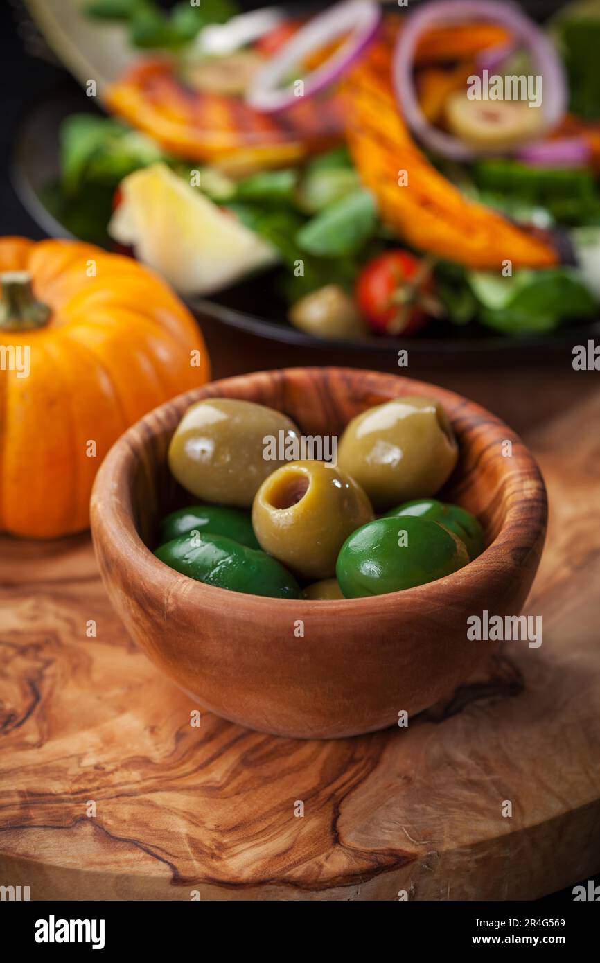 Delicious green olives in the bowl with salad Stock Photo