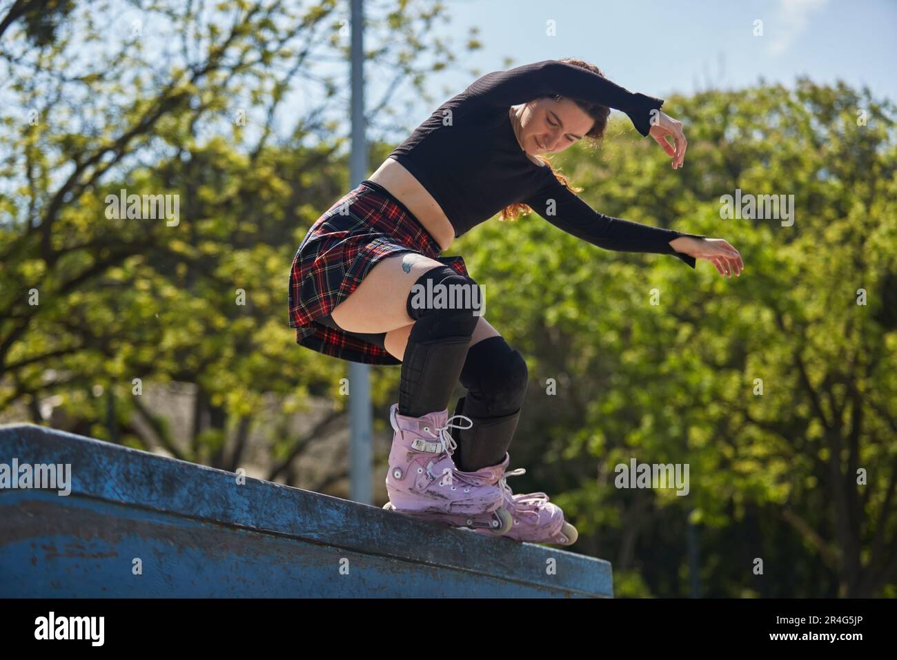 Roller blader female grinding on a ledge in a skatepark. Cool