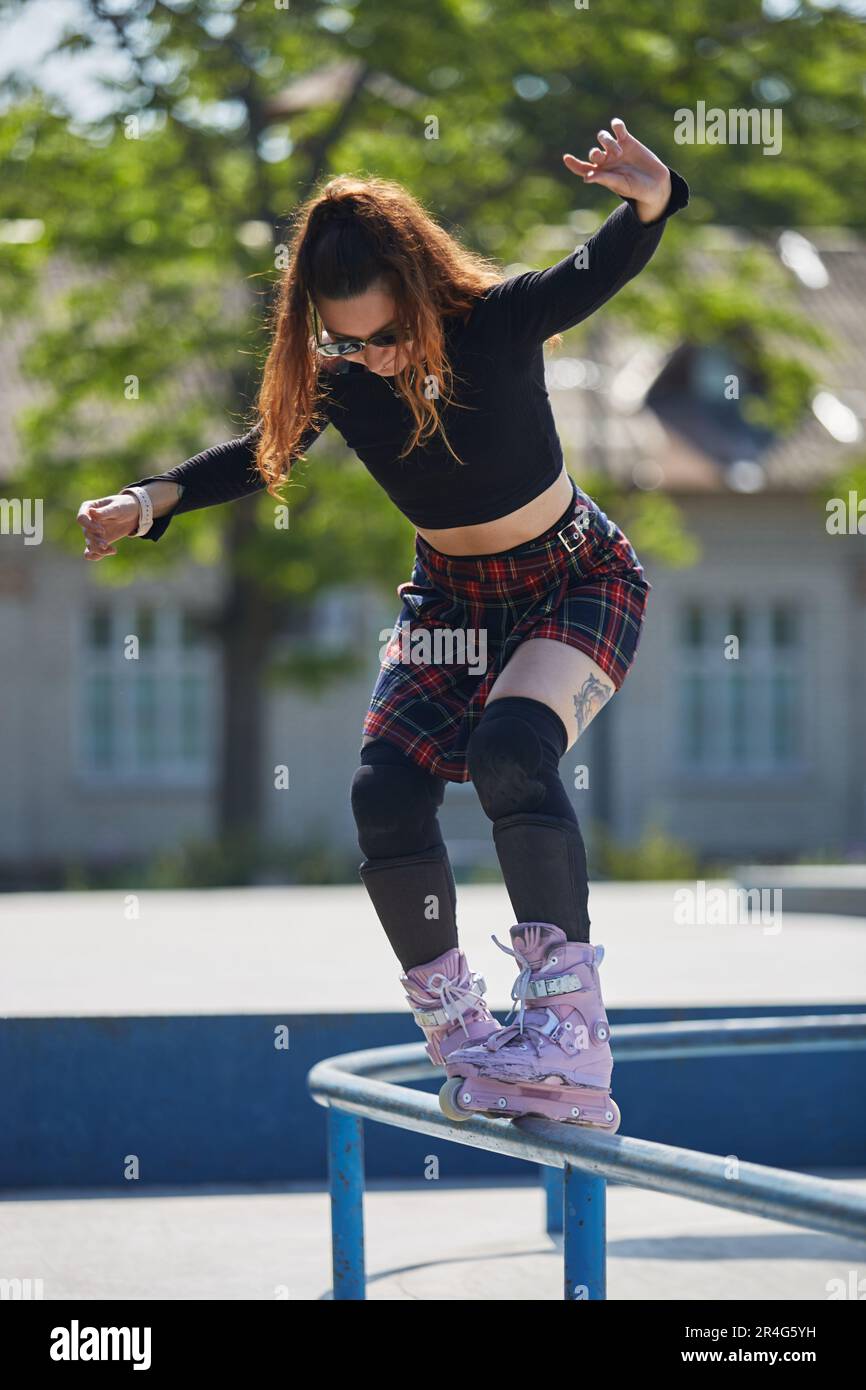 Cool young female grinding on a rail with aggressive inline skates