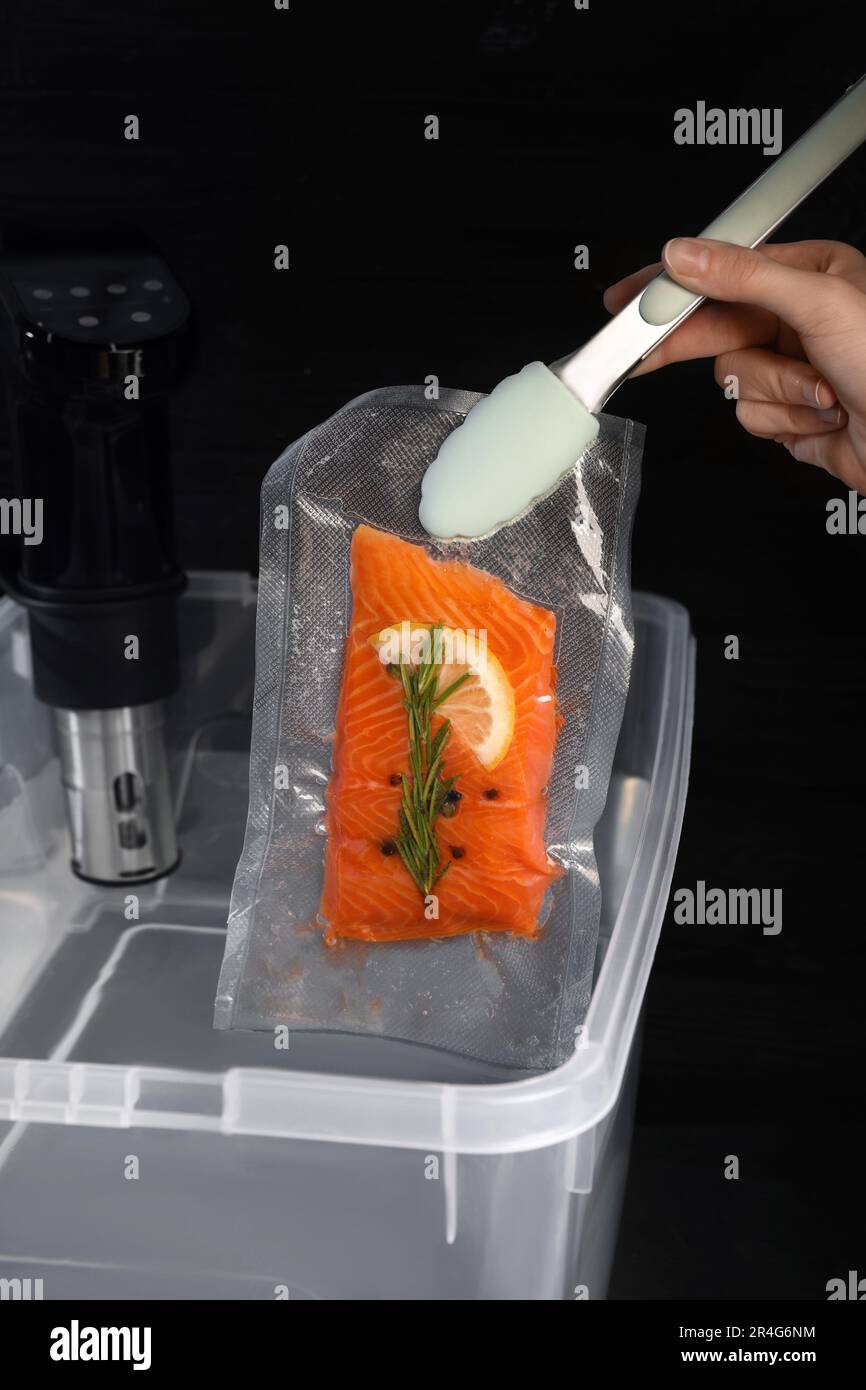 Woman putting vacuum packed salmon into box with thermal immersion