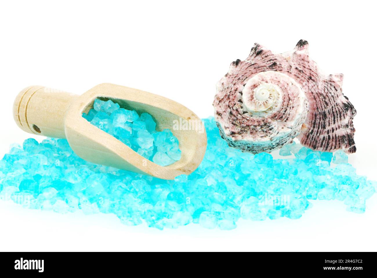Isolated blue bath salt in a woode spoon and a shell Stock Photo