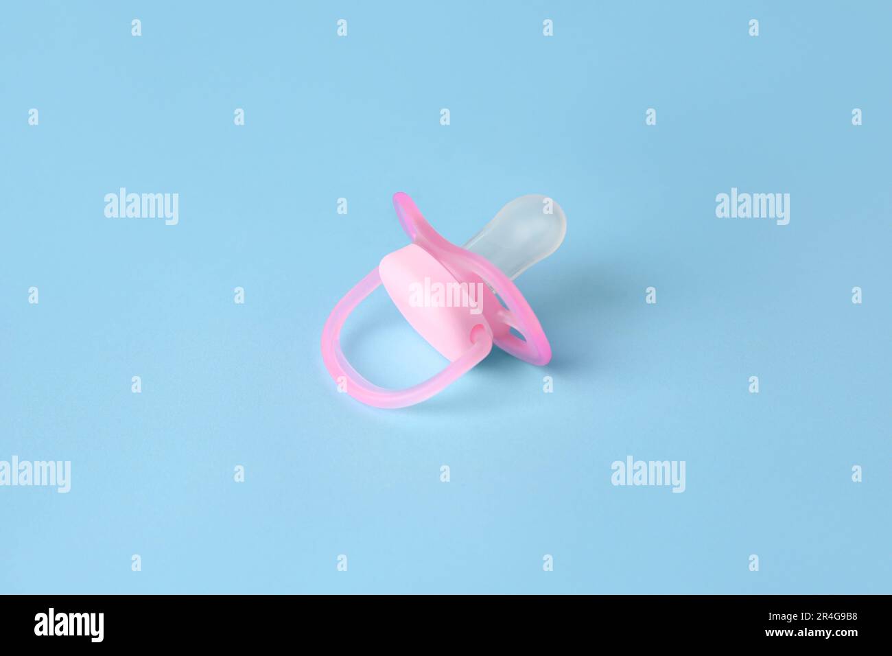 One new baby pacifier on light blue background Stock Photo