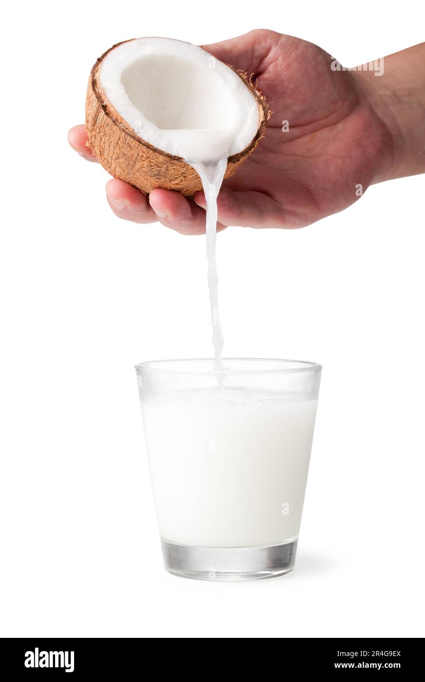 coconut milk is poured from the nut Stock Photo