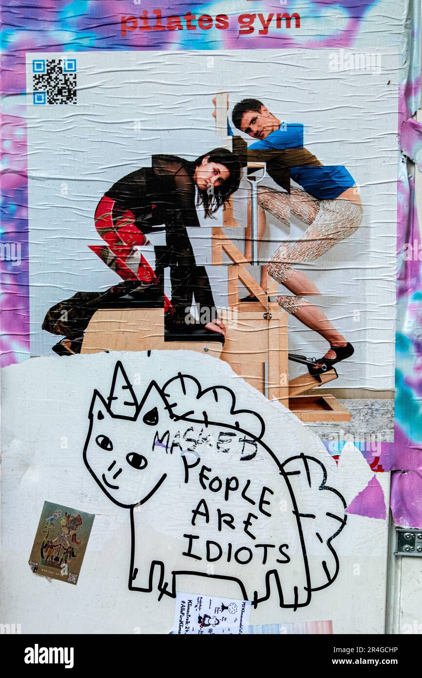 Urban humor, Torn Pilates Gym Poster and 'People are Idiots' graffiti, Neukölln, Berlin, Germany Stock Photo