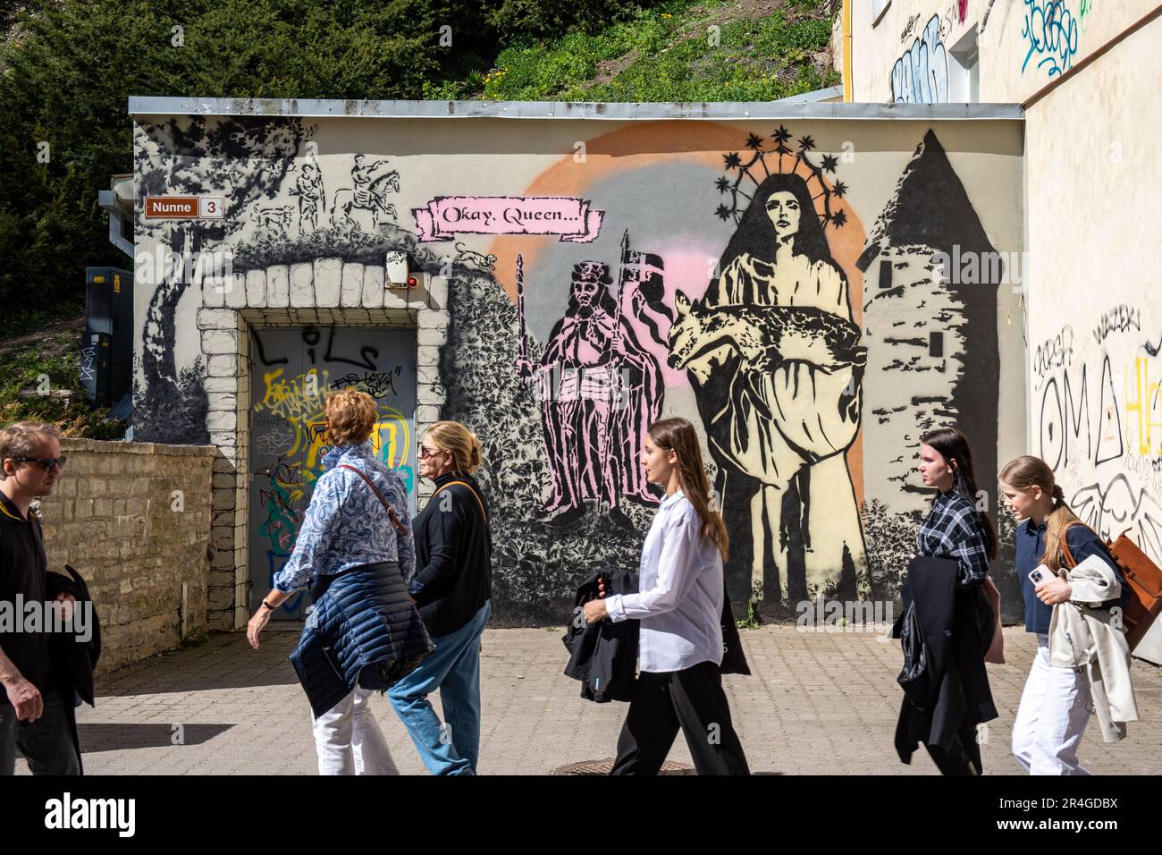 People passing large mural street art stencil graffiti by Marie Soosaar at Nunne 3 in Vanalinn, the old town of Tallinn, Estonia Stock Photo