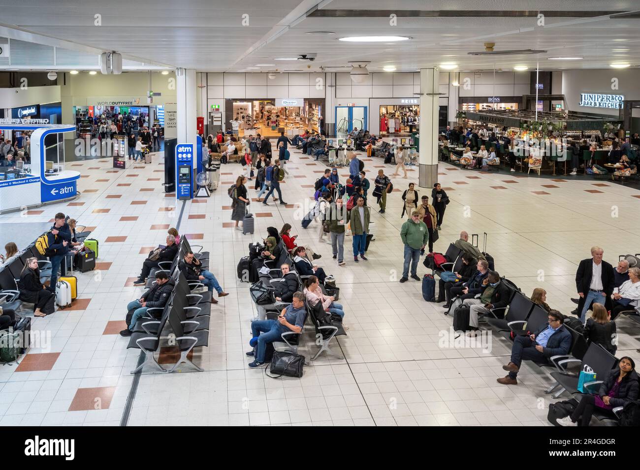 Gatwick Airport - interior of departure lounge in North Terminal with people waiting for their flights, England, UK. London Gatwick Stock Photo