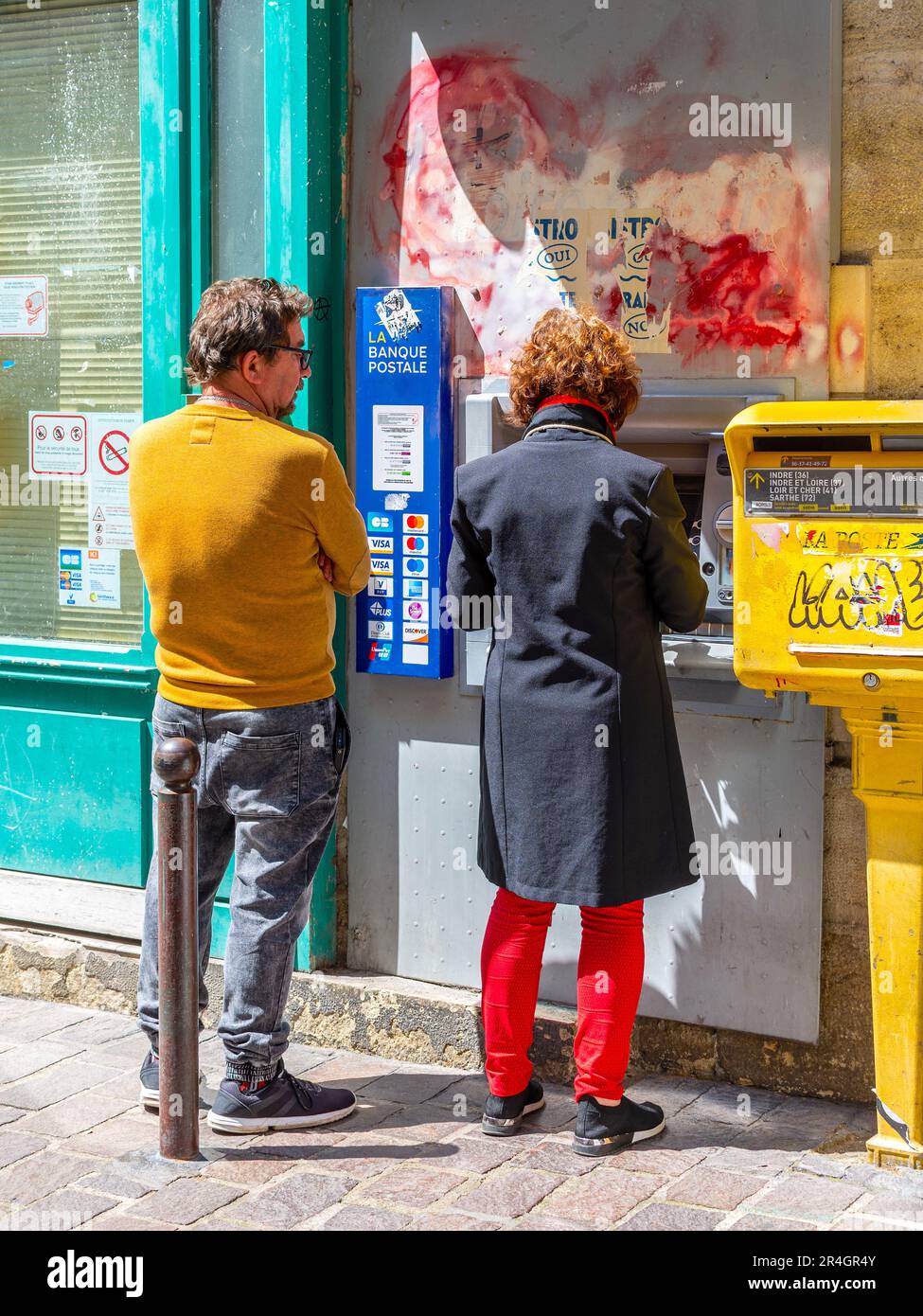 Couple at cash dispenser in city - Tours, Indre-et-Loire (37), France. Stock Photo