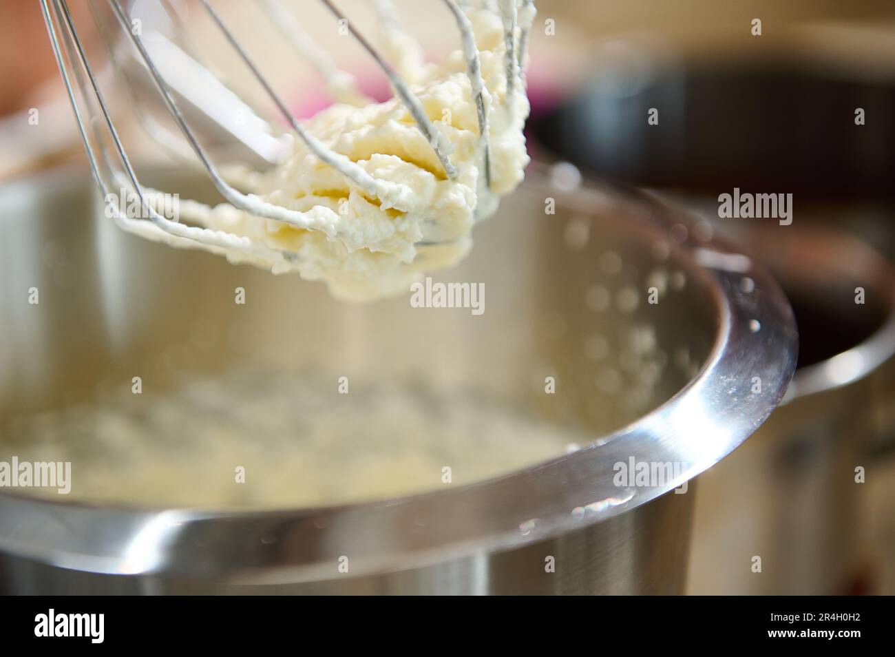 The process of whipping cream to firm peaks or egg whites in
