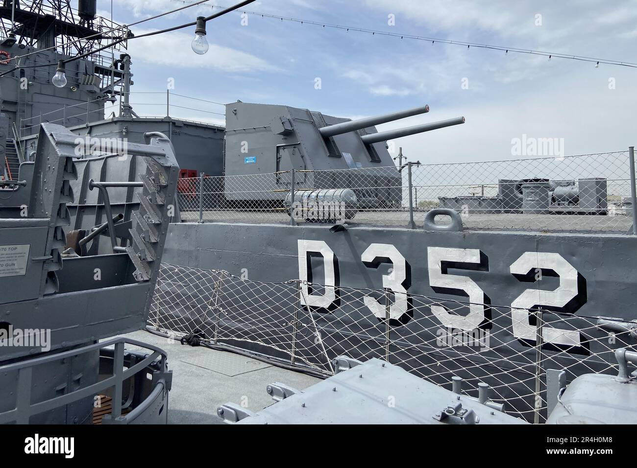 Outside details of retired vintage military naval sea vessel navy warship number, heavy machine gun, nautical flag, antenna, bridge of destroyer Stock Photo