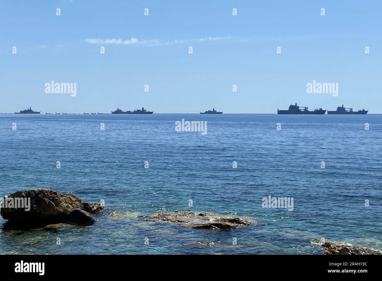 Navy activity on the Aegean Mediterranean Sea. Military vehicles ships transport for military drill operation in open sea with rocks on the seashore. Stock Photo