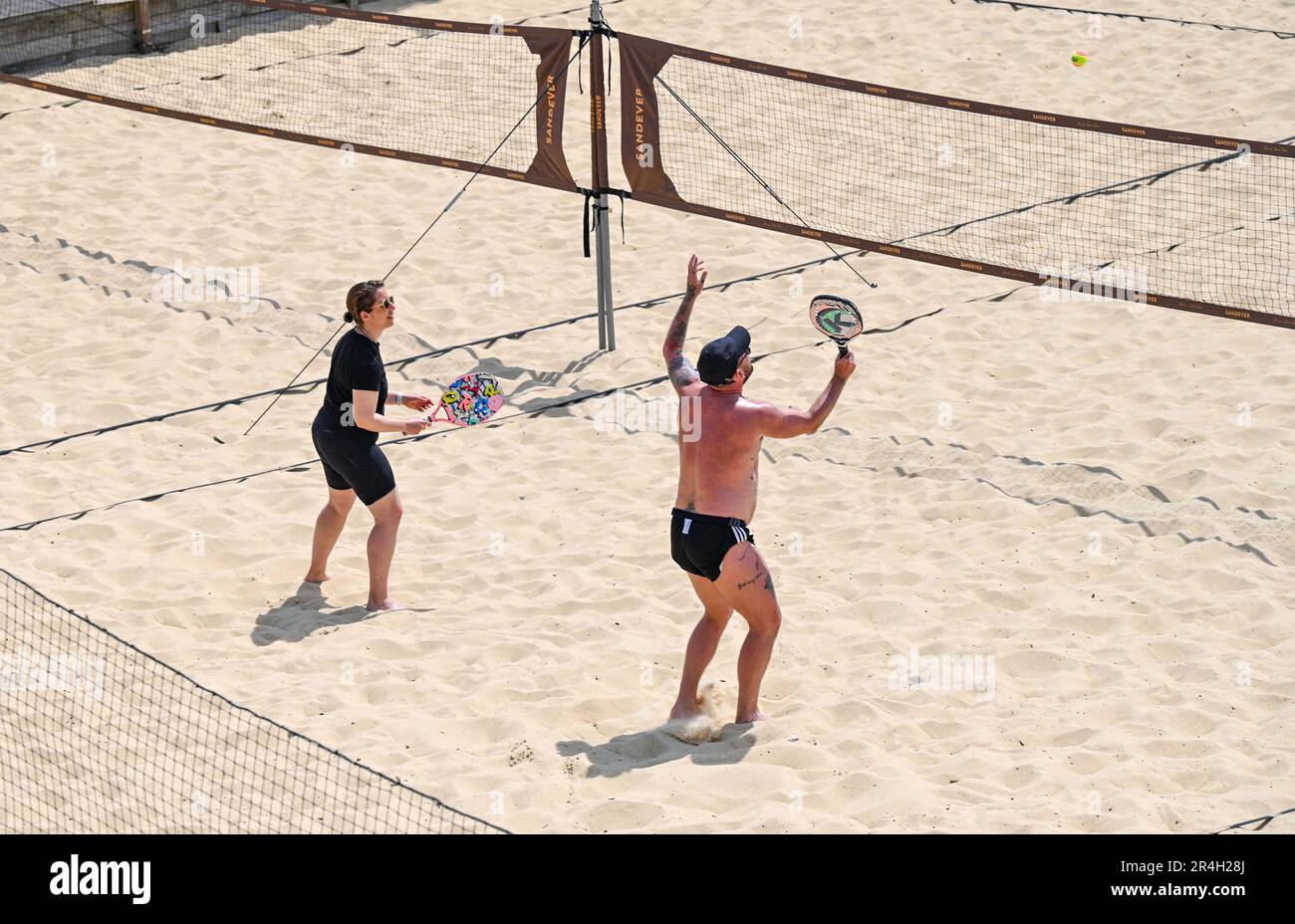 Brighton UK 28th May 2023 - Beach tennis players enjoy  a beautiful hot sunny day on Brighton beach during the bank holiday weekend with temperature reaching over 20 degrees in some parts of the UK : Credit Simon Dack / Alamy Live News Stock Photo