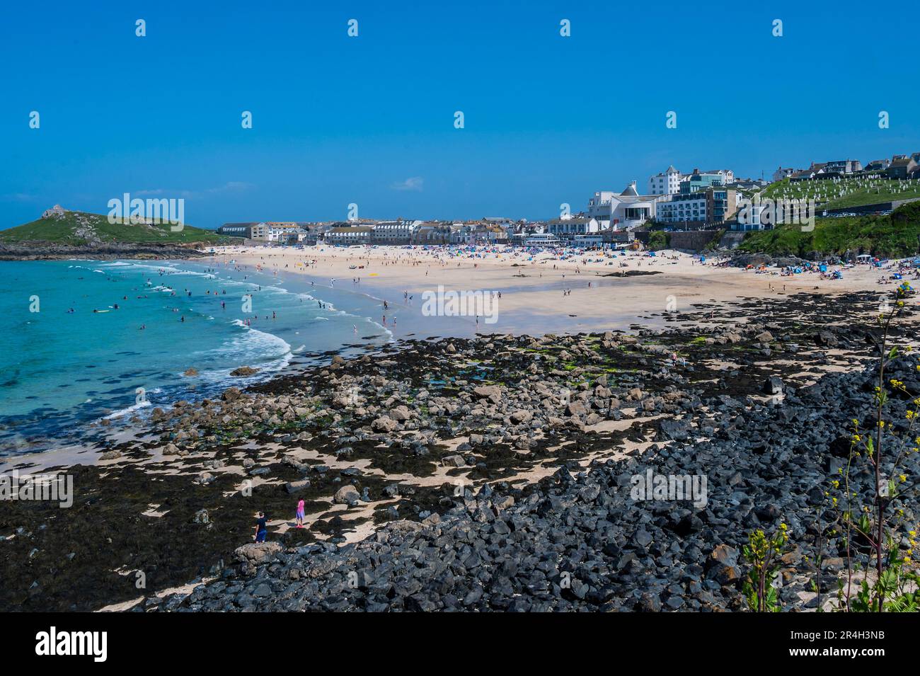 St Ives, UK. 27th May, 2023. People flock to the beach, in front of the Tate St Ives, to sunbathe as well as take part in watersports and boat trips - Sunny weather for the bank holiday Credit: Guy Bell/Alamy Live News Stock Photo