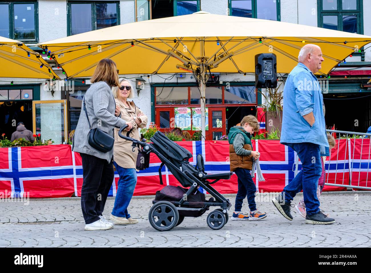 Stavanger, Rogaland, Norway, May 19 2023, Family Mother Women Man, Grandparents  Child Walking Past Bar Outside Terrace Downtown Stavanger Harbour Are Stock Photo