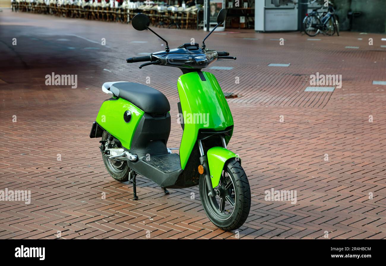 Scooter vintage moto parked downtown on paved street. Bright green